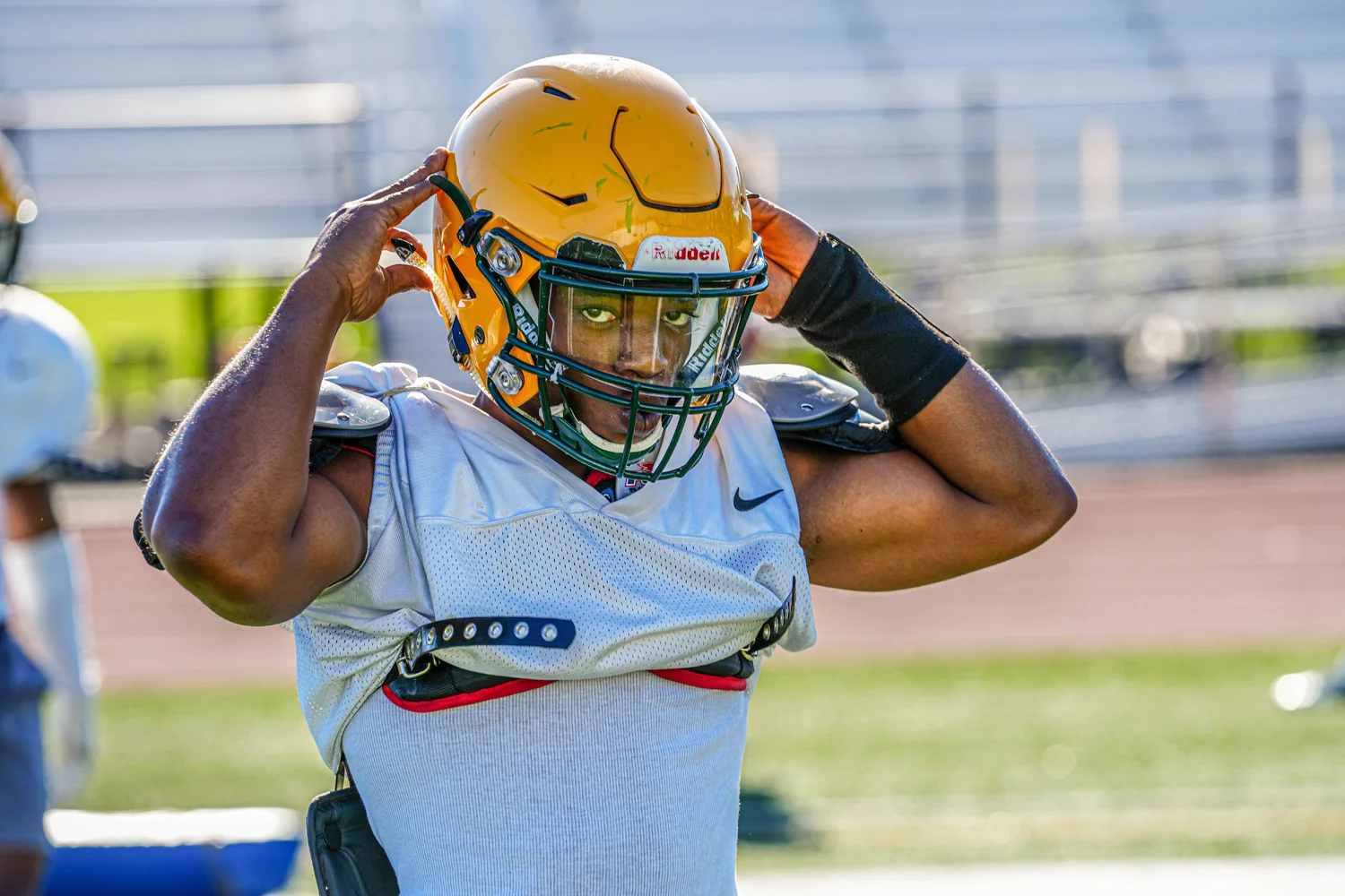 Brockport player buckling up the helmet