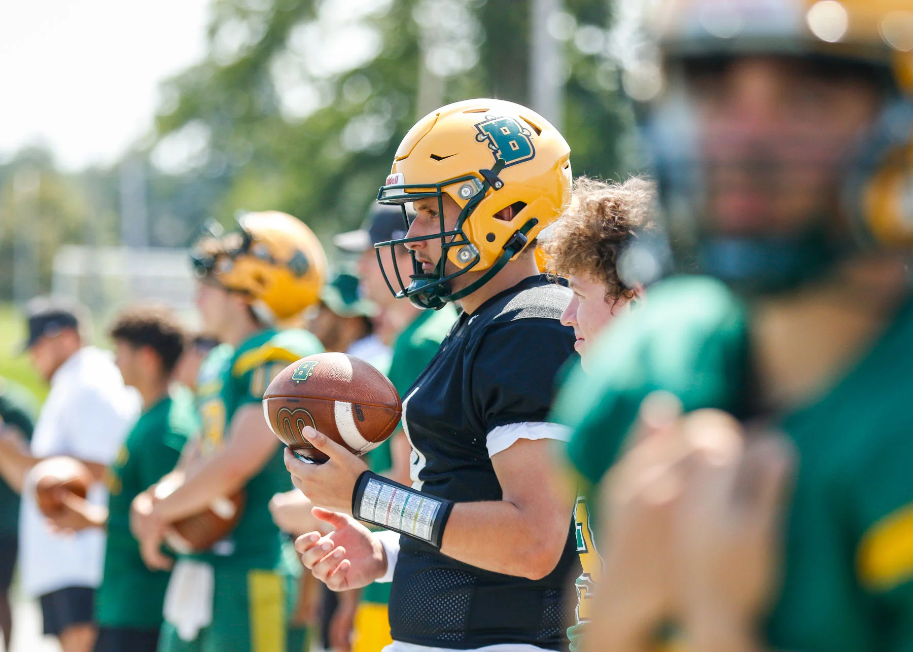 Brockort QB watching from the sidelines waiting to hit the field